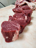 Close-up of marbled beef cuts with visible grain and fat distribution, highlighting the texture and freshness of